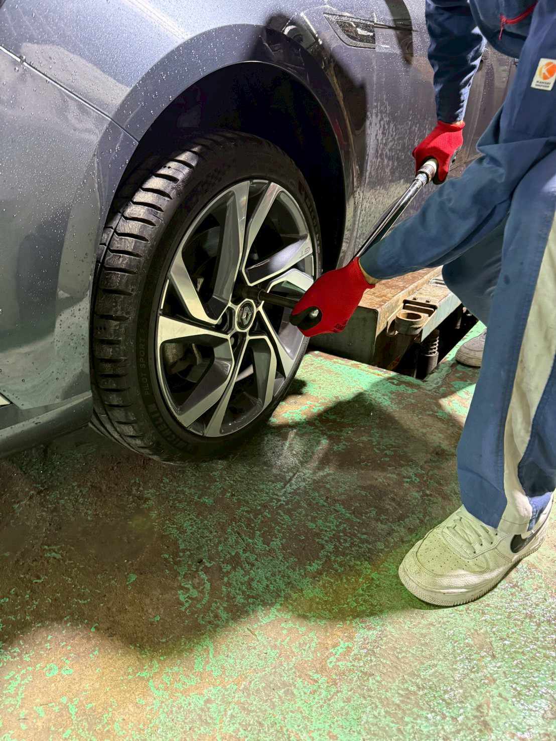 トルクレンチを使用してホイールナットを締め付ける整備作業
